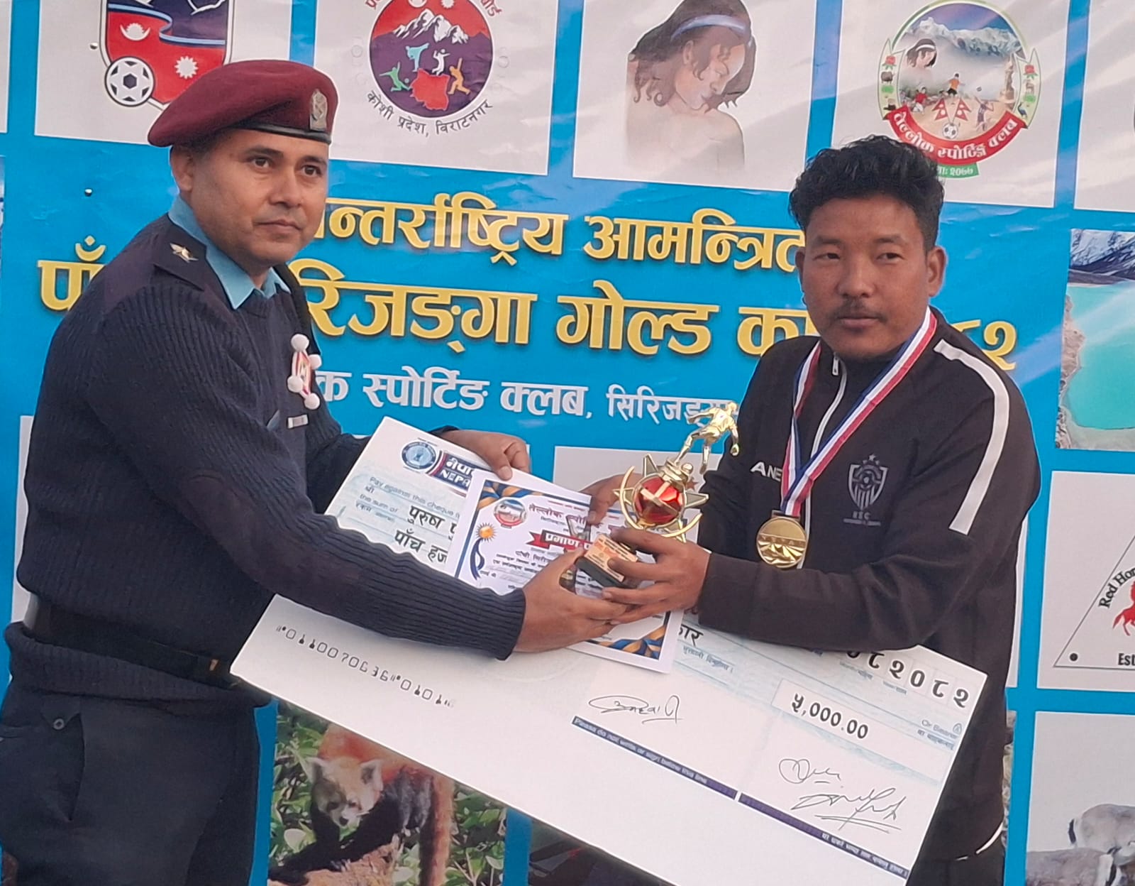 झापाका प्रशिक्षक आफ्ना खेलाडीको पुरस्कार ग्रहणगर्दै ।